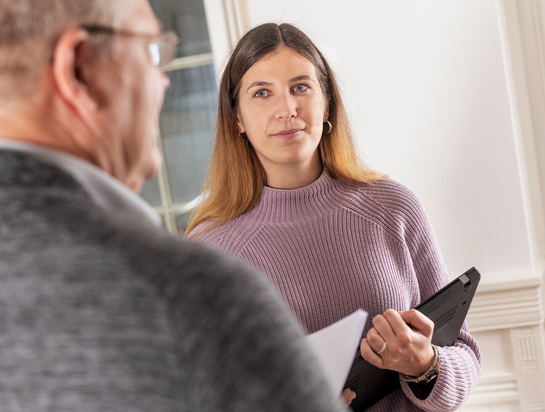 eine Mitarbeiterin im Gespräch mit einem Arbeitskollegen des Finanzamtes