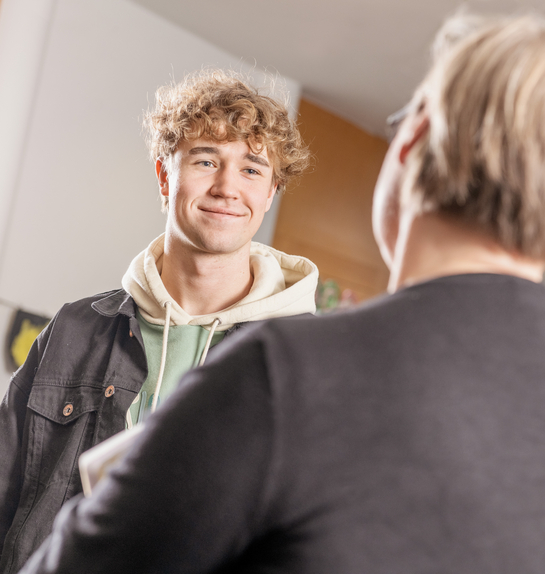 Ein Lernender im Gespräch mit einer Lehrbeauftragten