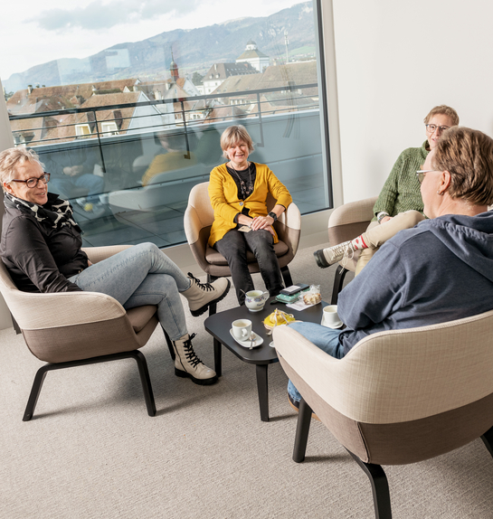 eine Gruppe von Arbeitskollegen unterhalten sich während der Pause in lockerer Umgebung