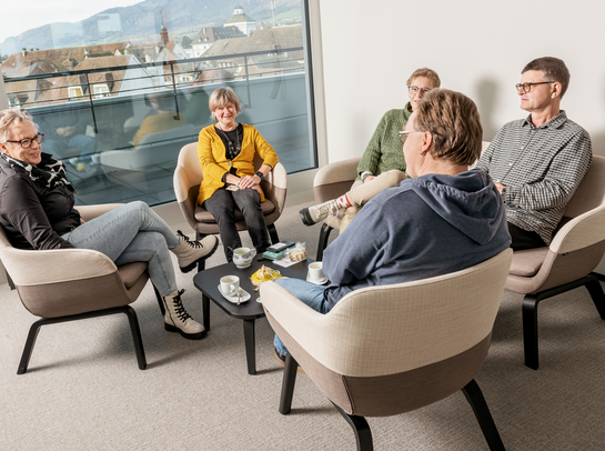 eine Gruppe von Arbeitskollegen unterhalten sich während der Pause in lockerer Umgebung