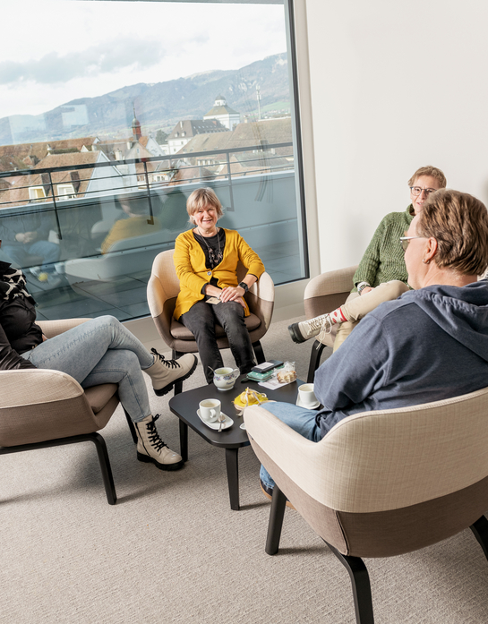 eine Gruppe von Arbeitskollegen unterhalten sich während der Pause in lockerer Umgebung