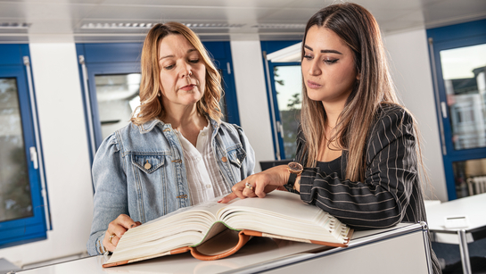 Zwei Mitarbeiterinnen der Amtschreiberei Solothurn unterhalten sich über einen Bucheintrag