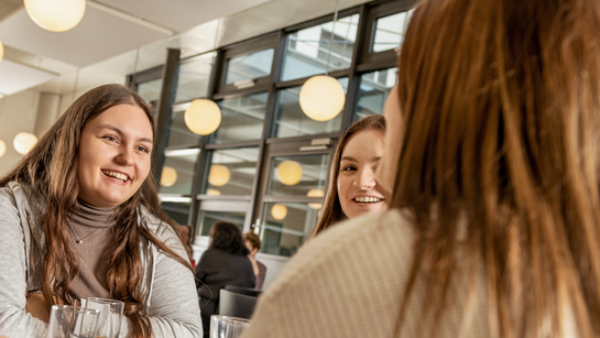 junge Arbeitskollegen unterhalten sich fröhlich in der Kantine