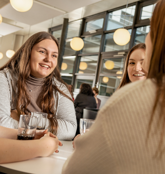 junge Arbeitskollegen unterhalten sich fröhlich in der Kantine