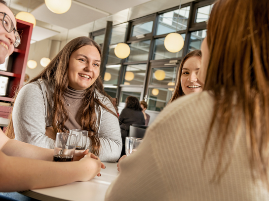 junge Arbeitskollegen unterhalten sich fröhlich in der Kantine