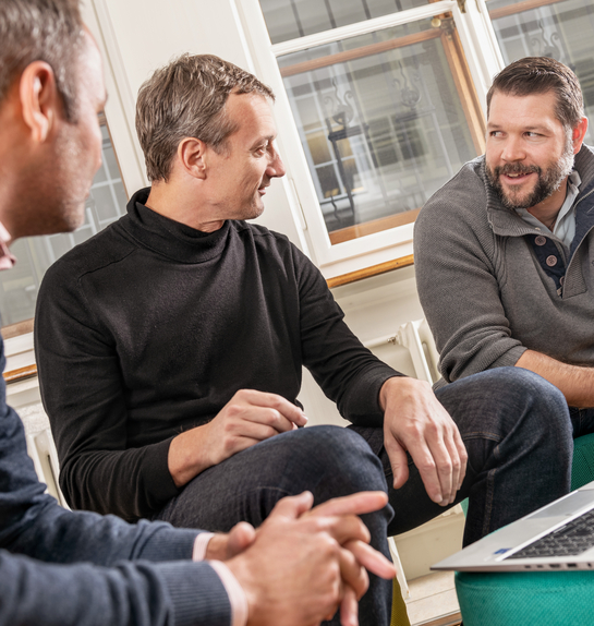 Drei IT-Spezialisten diskutieren über die Arbeit