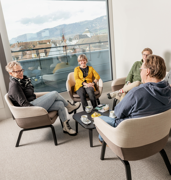eine Gruppe von Arbeitskollegen unterhalten sich während der Pause in lockerer Umgebung