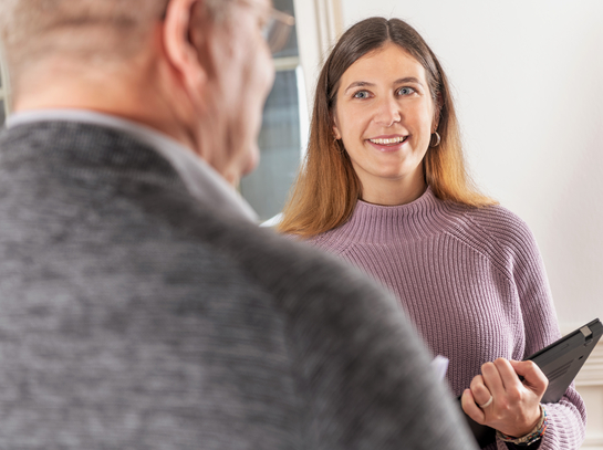 eine Mitarbeiterin im Gespräch mit einem Arbeitskollegen des Finanzamtes