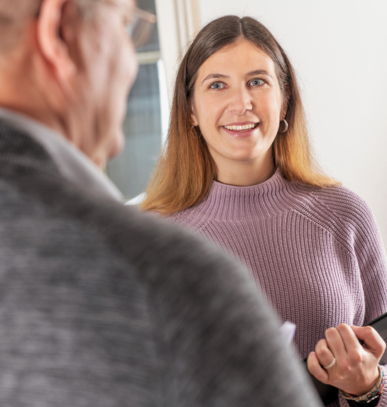 eine Mitarbeiterin im Gespräch mit einem Arbeitskollegen des Finanzamtes