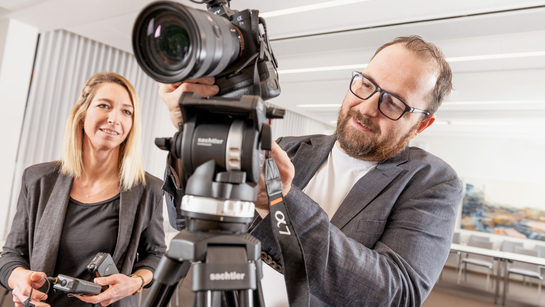 Zwei Mitarbeitende des zentrales Dienstes arbeiten mit einer Kamera