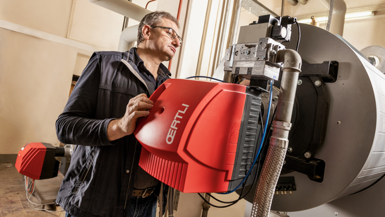 Mitarbeiter des Facility Managements hantiert an einer Maschine