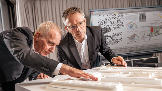 Zwei Mitarbeitende des Hochbauamts arbeiten an einem Gebäudemodell