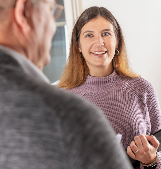 eine Mitarbeiterin im Gespräch mit einem Arbeitskollegen des Finanzamtes