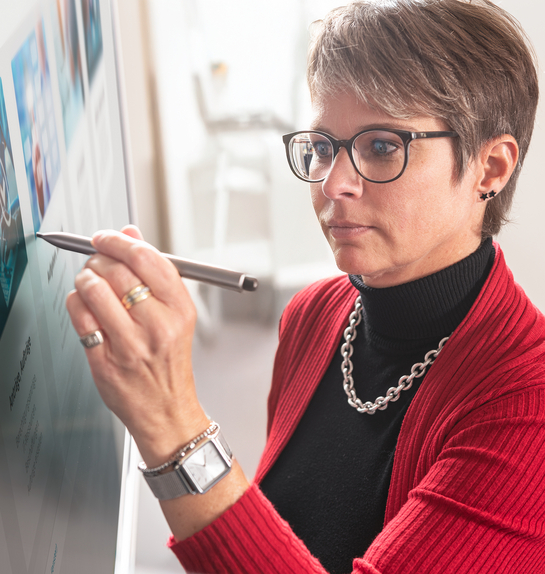 Eine IT-Spezialistin schreibt auf den Bildschirm in einem Meeting